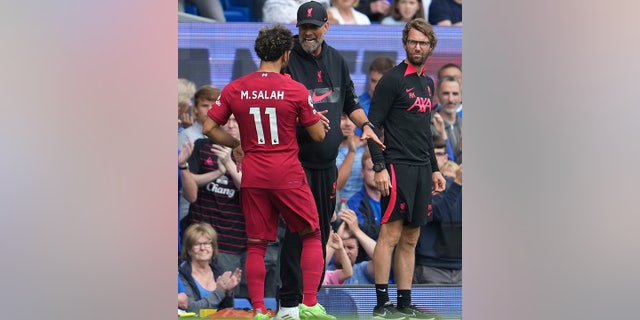 Liverpool's Mohamed Salah, left, talks with Liverpool's manager Jurgen Klopp during the English Premier League soccer match between Everton and Liverpool at Goodison Park, Liverpool, England, Saturday, Sept. 3, 2022.