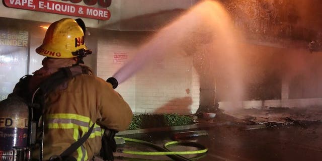 A Los Angeles firefighter is seen battling a fire in the Palms area of Los Angeles early September 17, 2022.