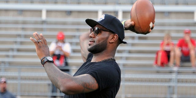 LeBron James throws a football prior to a game between the Wisconsin Badgers and the Ohio State Buckeyes at Ohio Stadium on Sept. 28, 2013 in Columbus, Ohio.