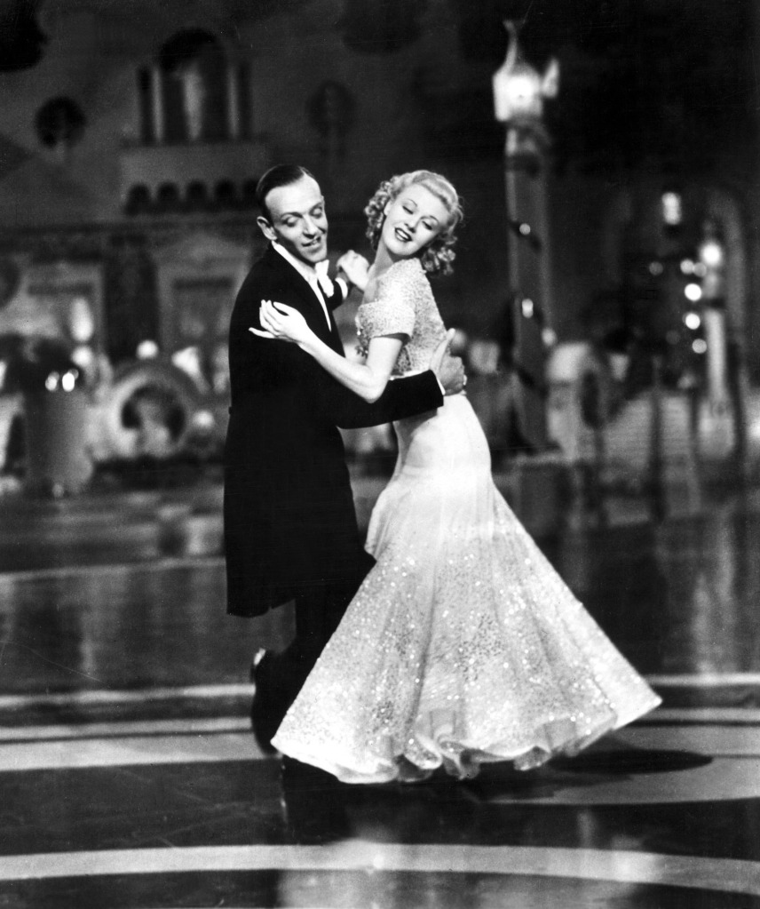Black-and-white photo of Fred Astaire dancing with Ginger Rogers in "Top Hat." He's wearing a tux and tails and she's wearing a gown.