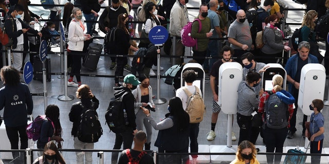 People are seen in a TSA security checkpoint line at Orlando International Airport two days before Christmas in 2021.