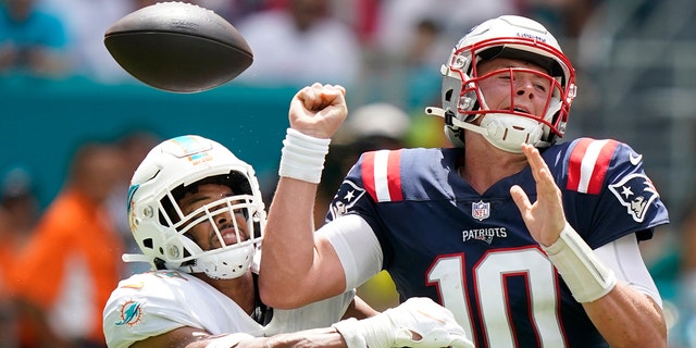 New England Patriots quarterback Mac Jones (10) fumbles the ball on a sack by Miami Dolphins safety Brandon Jones (29) during the first half of an NFL football game, Sunday, Sept. 11, 2022, in Miami Gardens, Fla. The fumble lead to a touchdown by the Miami Dolphins.