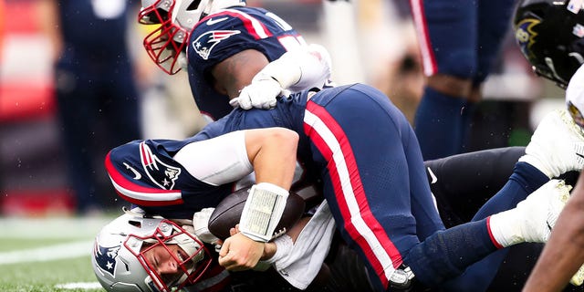 Quarterback Mac Jones of the New England Patriots reacts after being sacked during the fourth quarter against the Baltimore Ravens at Gillette Stadium on Sept. 25, 2022, in Foxborough, Massachusetts.