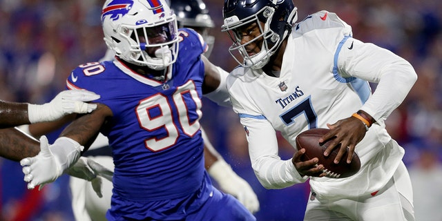 Malik Willis, #7 of the Tennessee Titans, scrambles against Shaq Lawson, #90 of the Buffalo Bills, during the third quarter of the game at Highmark Stadium on Sept. 19, 2022 in Orchard Park, New York.