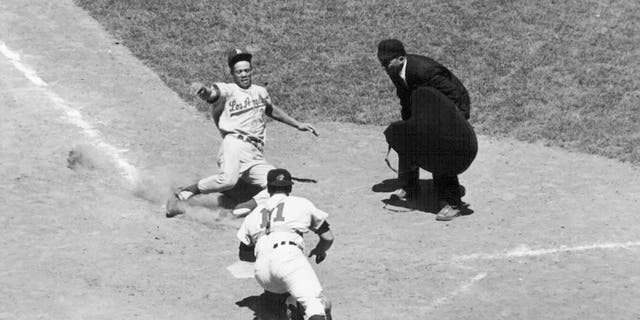 Los Angeles Dodgers' Maury Wills slides safely home past John Romano of the Cleveland Indians during the eighth inning of the All-Star Game in Washington on July 10, 1962.