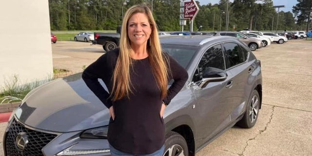 Missing Texas teacher Michelle Reynolds standing in front of her gray Lexus SUV. She was last heard from Thursday, and her car was located in New Orleans.