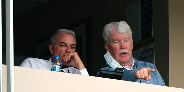 General manager Dayton Moore (L) and owner John Sherman of  the Kansas City Royals watch a game against the Milwaukee Brewers in the first inning at Kauffman Stadium on May 18, 2021 in Kansas City, Missouri.