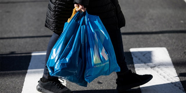 A shopper carries plastic bags in the Manhattan borough of New York City March 1, 2020.