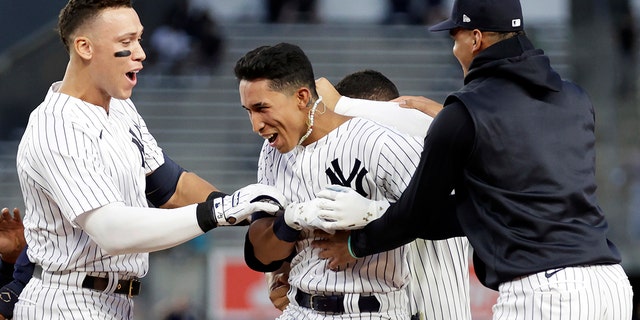 New York Yankees' Oswaldo Cabrera is congratulated by teammates after he drove in the winning run with a single during the 12th inning against the Minnesota Twins in the first baseball game of a doubleheader Wednesday, Sept. 7, 2022, in New York. 