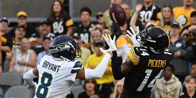 George Pickens (14) of the Pittsburgh Steelers makes a catch for a 26-yard touchdown reception as Coby Bryant (8) of the Seattle Seahawks defends in the first quarter during a preseason game at Acrisure Stadium Aug. 13, 2022, in Pittsburgh.