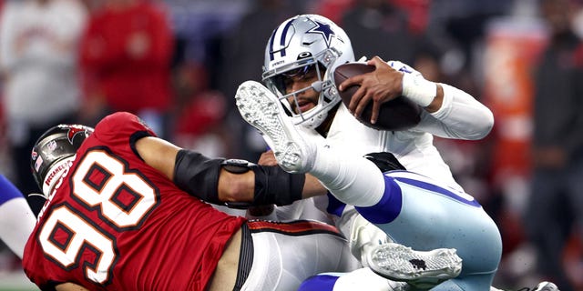 Anthony Nelson #98 of the Tampa Bay Buccaneers sacks Dak Prescott #4 of the Dallas Cowboys during the second half on September 11, 2022, in Arlington, Texas.