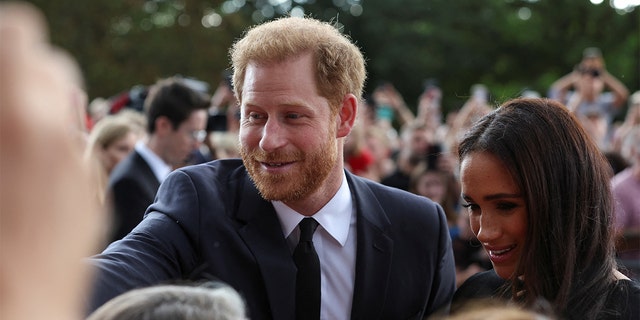 Britain's Prince Harry and Meghan, the Duchess of Sussex, greet people as they walk outside Windsor Castle, following the passing of Britain's Queen Elizabeth, in Windsor, Britain, Sept. 10, 2022. 