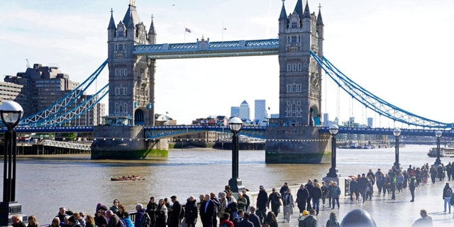 Members of the public line up Saturday, Sept. 17, 2022, near Tower Bridge as they wait to view Queen Elizabeth II lying in state ahead of her funeral on Monday in London.