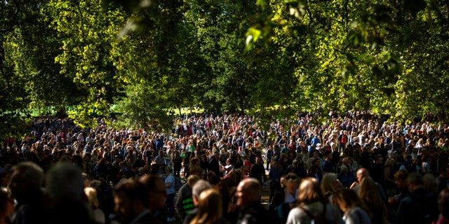 People gather to bring flowers for Queen Elizabeth II at Green Park, near Buckingham Palace in London, Saturday, Sept. 17, 2022.  