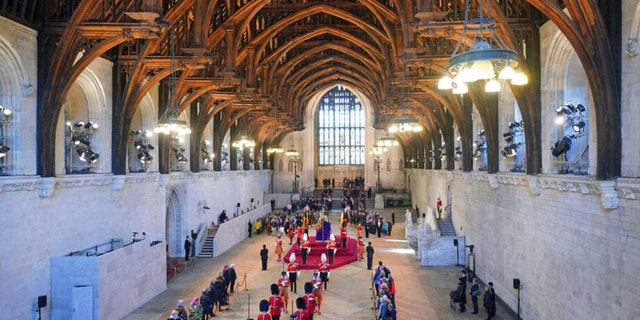 The guard is changed while members of the public file past the coffin of Queen Elizabeth II in Westminster Hall at the Palace of Westminster in London Saturday, Sept. 17, 2022. 