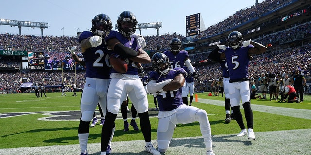 Baltimore Ravens safety Marcus Williams (32) celebrates with teammates after intercepting a pass during the first half against the Miami Dolphins in Baltimore on Sept. 18, 2022.