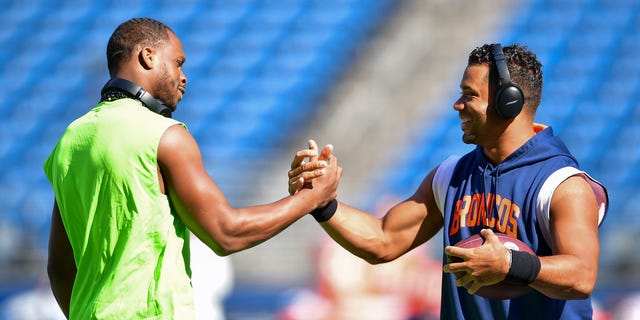 Geno Smith #7 of the Seattle Seahawks (L) and Russell Wilson #3 of the Denver Broncos shake hands before a game at Lumen Field on September 12, 2022 in Seattle, Washington.