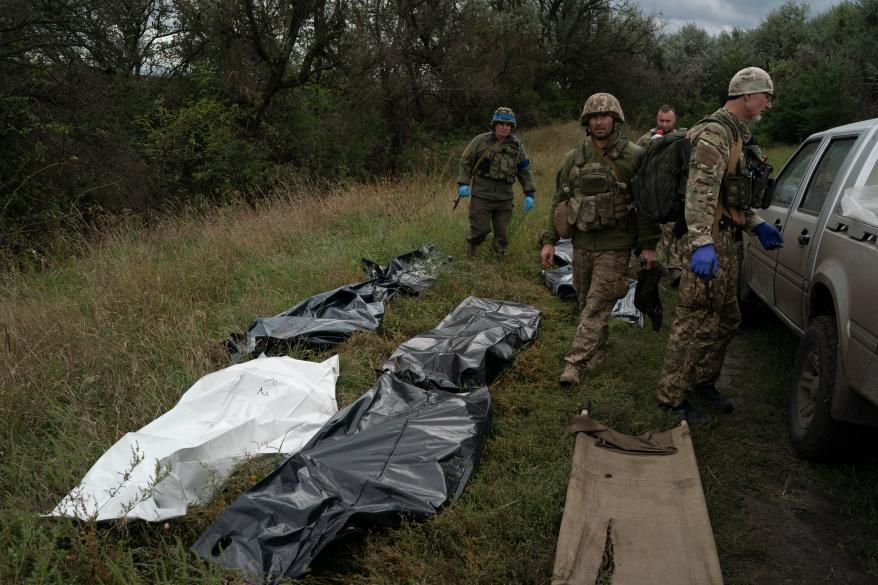 Ukrainian national guard servicemen stand next to bags containing the bodies of seven Ukrainian soldiers recovered from an area near the border with Russia.