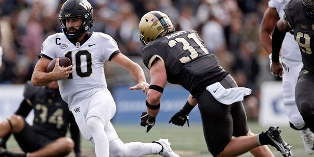 Wake Forest quarterback Sam Hartman (10) runs past Army linebacker Karsonne Winters (31) during the first half of an NCAA college football game Saturday, Oct. 23, 2021, in West Point, N.Y.