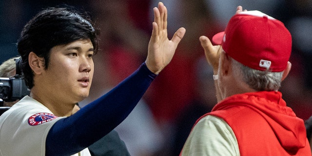 Los Angeles Angels starting pitcher Shohei Ohtani celebrates with interim manager Phil Nevin after the Angels defeated the Seattle Mariners 2-1, Saturday, Sept. 17, 2022, in Anaheim, California.