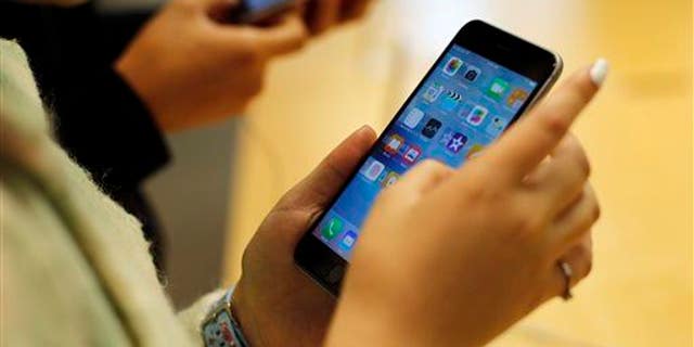 Customers try out a new Apple iPhone 6S at an Apple store on Chicago's Magnificent Mile, Friday, Sept. 25, 2015, in Chicago.