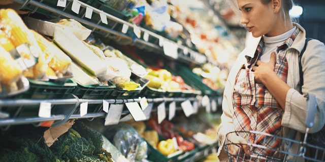 A woman buys groceries at the store. Read food labels carefully, say health experts and nutritionists. 