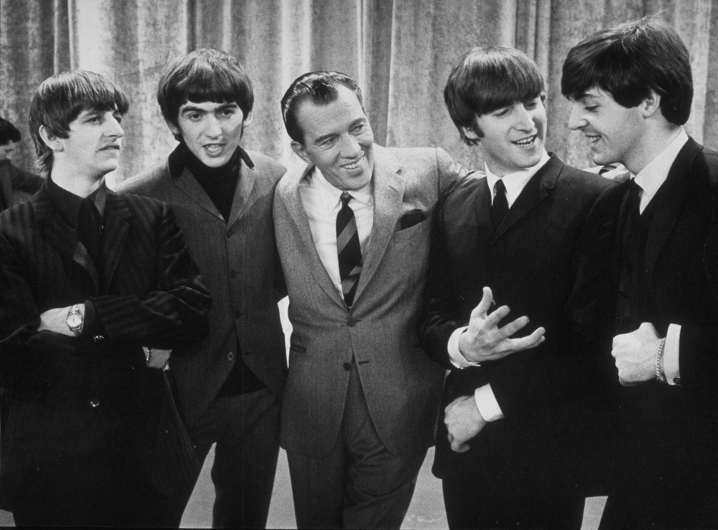 The Beatles became an American sensation very much due to radio DJ "Cousin Brucie" Morrow. They are seen with Ed Sullivan.