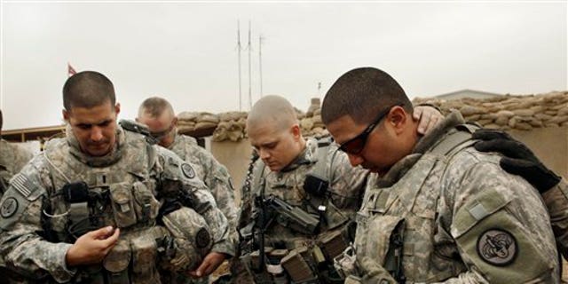 Army Lt. Daniel McCord, left, Staff Sgt. Marc Krugh, center, and Sgt. Christopher Torrentes, from the 3rd Armored Cavalry Regiment pray before heading out on a patrol at Contingency Operating Site Kalsu, south of Baghdad, Iraq.