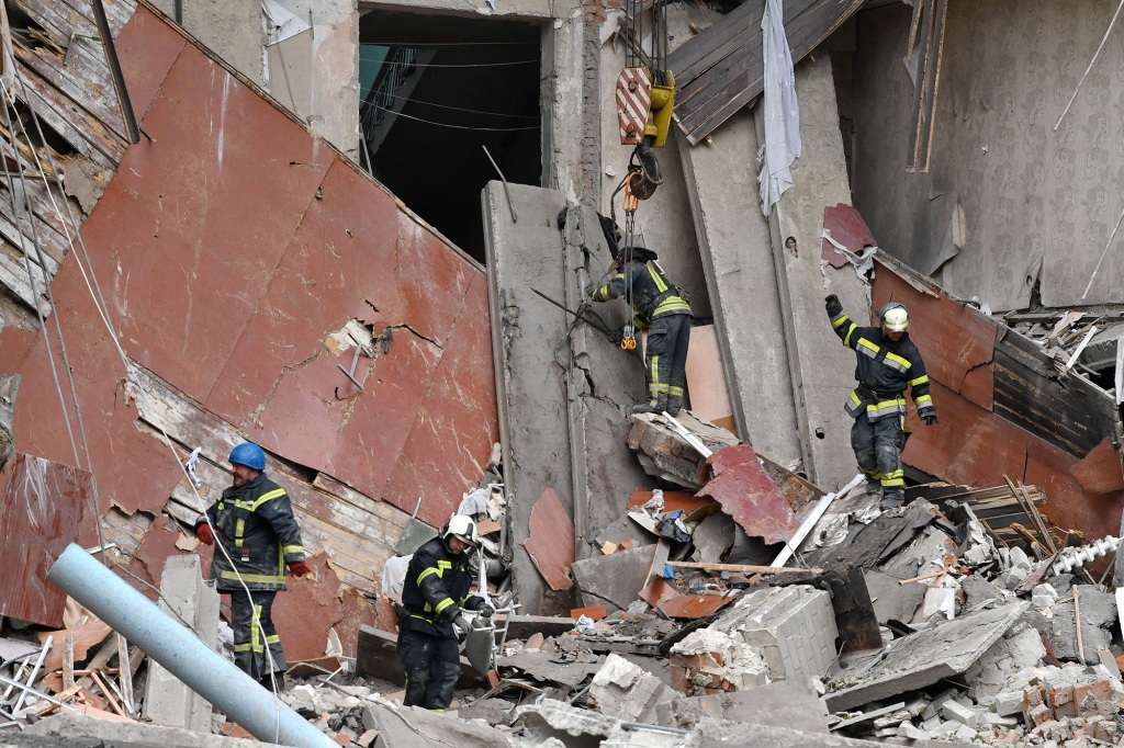 Rescuers work at a site of a high school that was heavily damaged by Russian shelling in Mykolaivka. 