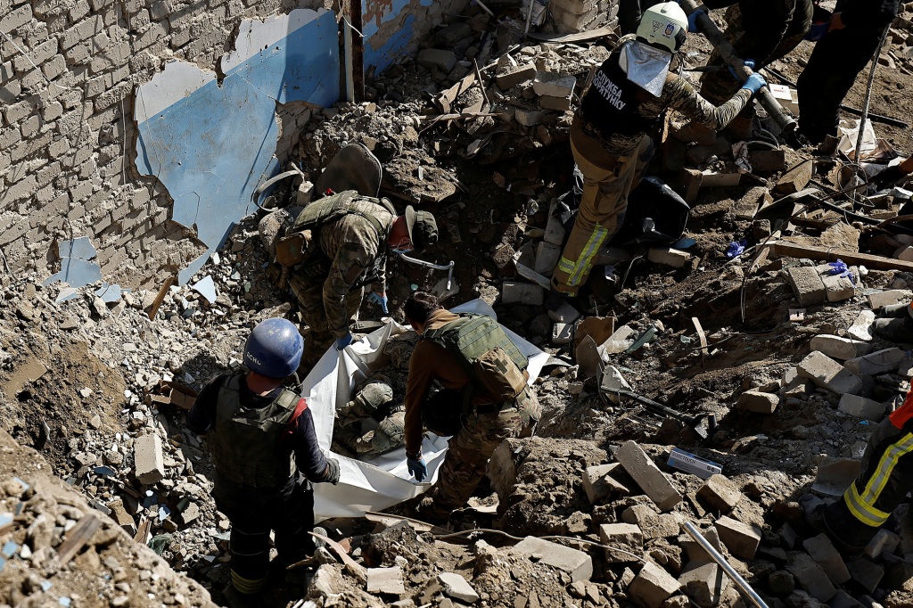 Ukrainian army soldiers prepare to extract their comrade's body who was found under the rubble of the building beside the TV tower, that was hit by Russian missile, in the recently liberated town of Izium, Kharkiv region.