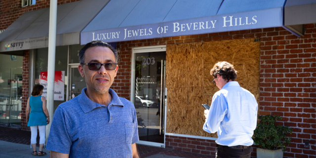 Owner Peter Sedghi stands on the street in front of his boarded up shop, Luxury Jewels of Beverly Hills on Wednesday, March 23, 2022, in Beverly Hills, Calif. 