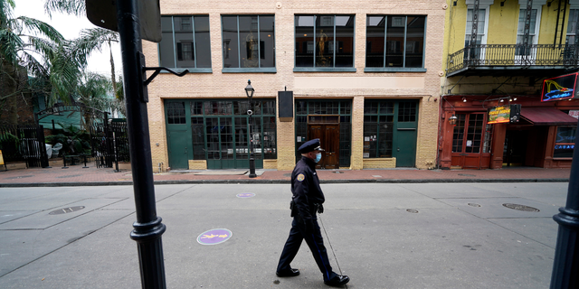 A police officer walks down a nearly deserted Bourbon Street during Mardi Gras in the French Quarter of New Orleans, Tuesday, Feb. 16, 2021. Hoping to beef up a dwindling police force amid a rise in violent crime, New Orleans officials announced a three-year $80 million plan Thursday, Sept. 8, 2022, offering raises for all officers, free health care and $30,000 in incentive payments for new hires. 