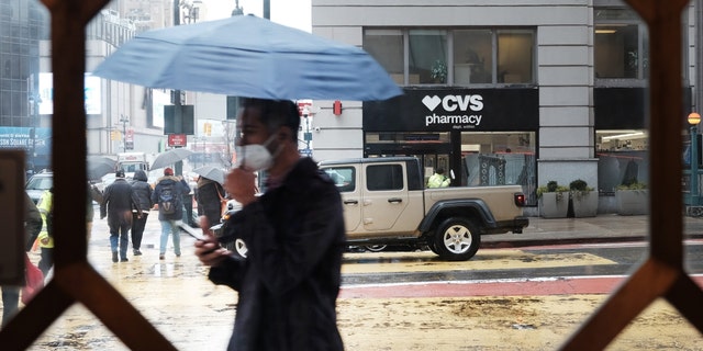 People walk through the rain and sleet in Manhattan as temperatures begin to fall on Feb. 4, 2022, in New York City. 