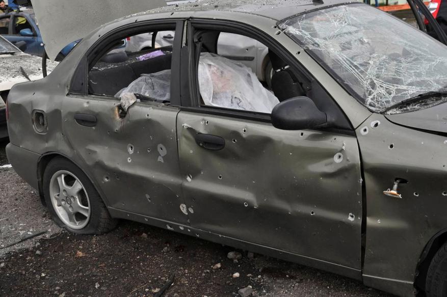 A car riddled with bullets and missile strikes shows a body in the passenger seat after the attack in Zaporizhzhia on Sept. 30, 2022.