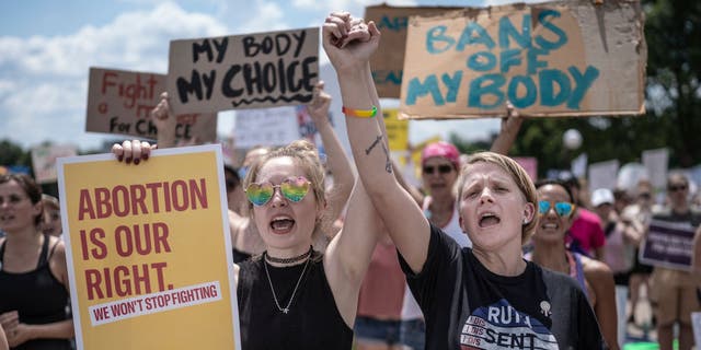 McKayla Wolff, left, and Karen Wolff, join hands as they rally for abortion rights at the capitol in St. Paul, Minn., on July 17, 2022.