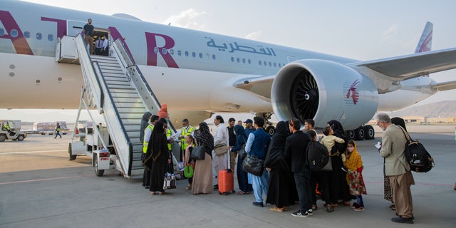 Afghan passengers are pictured in-front of a Qatar Airways airplane at Kabul International Airport, in Kabul, Afghanistan Sept. 19, 2021. (Qatar's Ministry of Foreign Affairs/Handout via REUTERS)