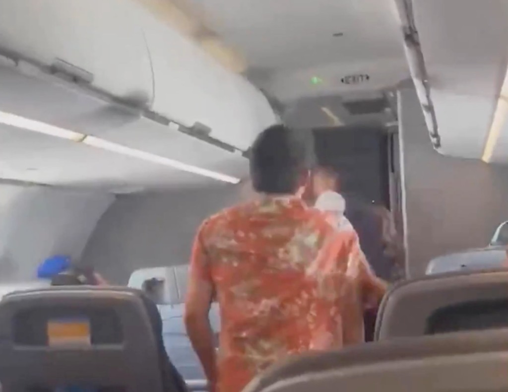 A witness said the man in the orange shirt was talking about killers on the flight before the male crew member confronted him. 