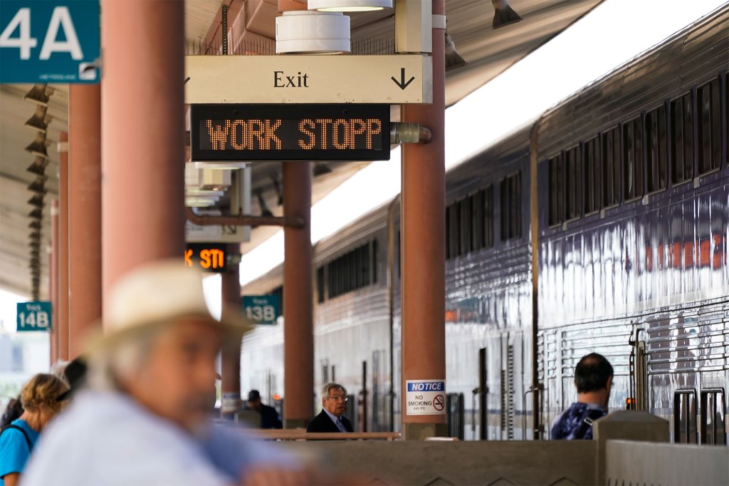 People wait on an Amtrak train platform at Union Station in Los Angeles