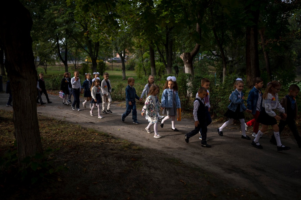 Students walk together entering in their class during their first day of school at a public school in Irpin.