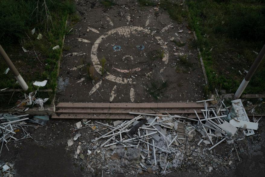 A drawing depicting a smiley sun decorates the entrance of a destroyed school among debris after Russian attacks that occurred in May, in Kostiantynivka.