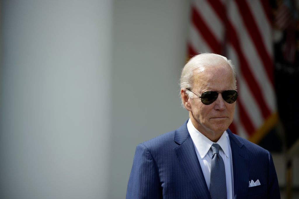 President Biden is shown scowling in dark sunglasses 