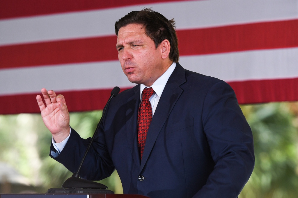 Gov. Ron DeSantis is shown waving in front of an American flag