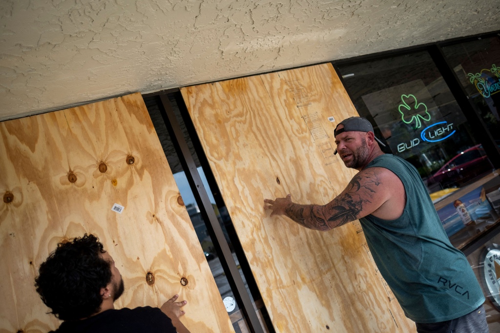 Floridians are shown boarding up windows with plywood ahead of Hurricane Ian