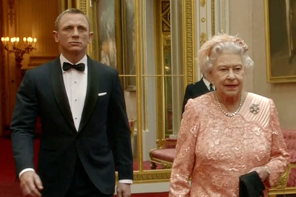 In this file television screen grab image taken on July 29, 2012, shows footage featured during the Opening Ceremony of the London 2012 Olympic Games starring British actor Daniel Craig (L) playing James Bond escorting Britain's Queen Elizabeth II through the corridors of Buckingham Palace. - Queen Elizabeth II, the longest-serving monarch in British history and an icon instantly recognisable to billions of people around the world, has died aged 96, Buckingham Palace said on September 8, 2022. Her eldest son, Charles, 73, succeeds as king immediately, according to centuries of protocol, beginning a new, less certain chapter for the royal family after the queen's record-breaking 70-year reign. (Photo by LOCOG / AFP) (Photo by -/LOCOG/AFP via Getty Images)