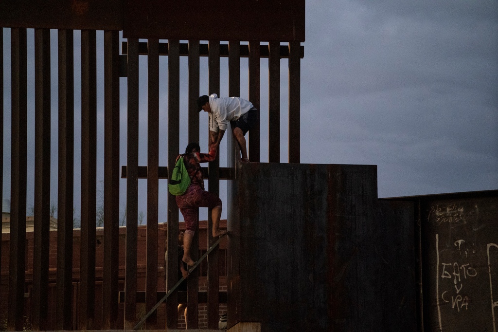 A man is seen lifting a woman on their way to crossing the US-Mexico border in El Paso, Texas.