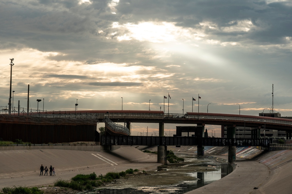 Asylum-seeking migrants walk next to the border wall after crossing the Rio Grande to El Paso, Texas, U.S., as seen from Ciudad Juarez, Mexico, September 26, 2022.