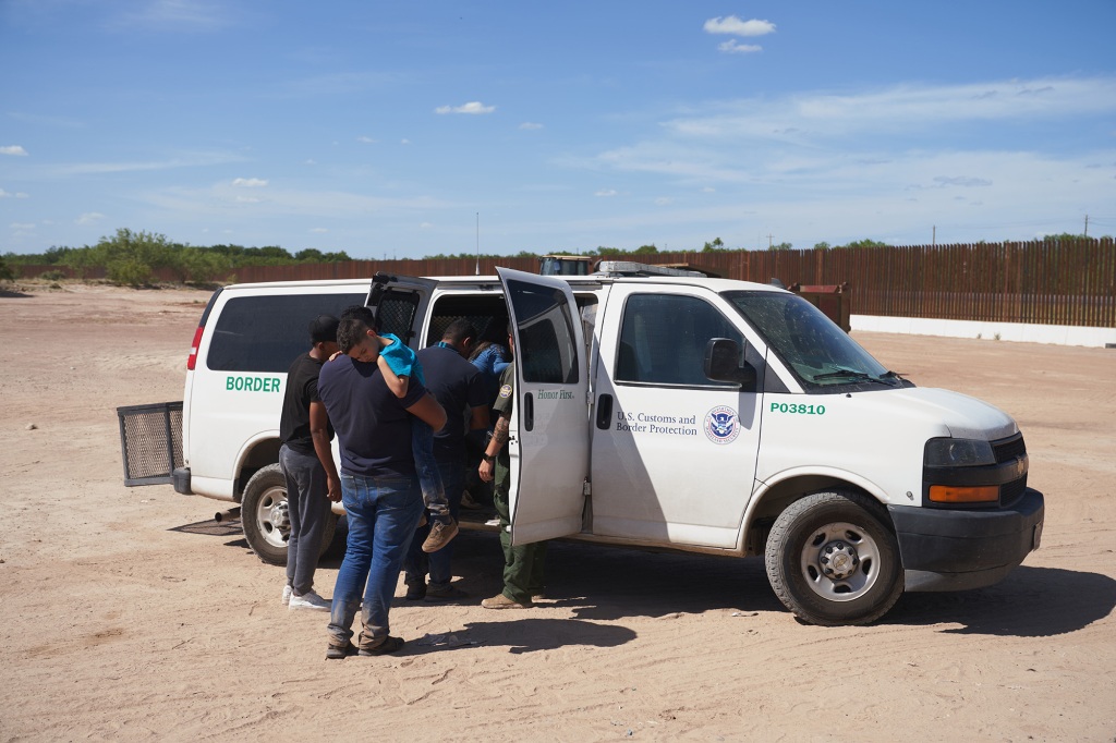 Migrants are transported after waiting in high heat to be processed by U.S. Border Patrol after illegally crossing into Eagle Pass, Texas.