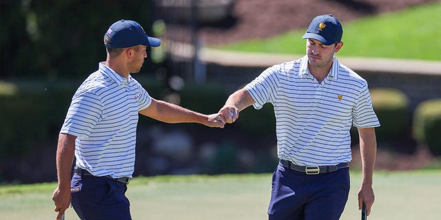 Xander Schauffele and Patrick Cantlay of the United States Team celebrate on the seventh green during Friday four-ball matches of the 2022 Presidents Cup at Quail Hollow Country Club Sept. 23, 2022, in Charlotte, N.C.