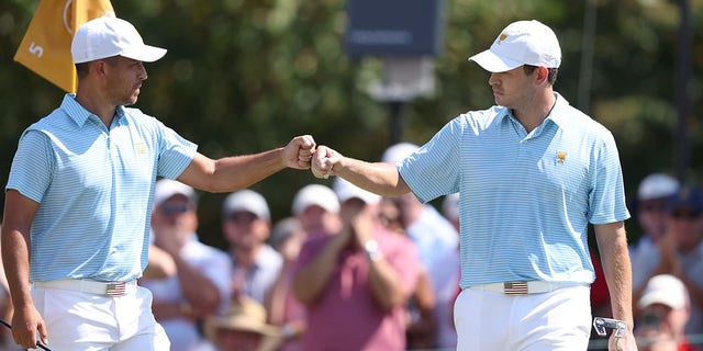 (L-R) Xander Schauffele of the United States Team and Patrick Cantlay of the United States Team fist bump on the fifth green during the Thursday foursome matches on day one of the 2022 Presidents Cup at Quail Hollow Country Club on September 22, 2022 in Charlotte, North Carolina.