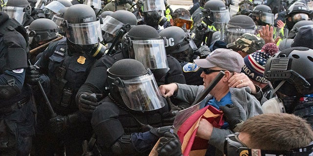 Capitol police officers in riot gear push back demonstrators on Wednesday, Jan. 6, 2021, in Washington.